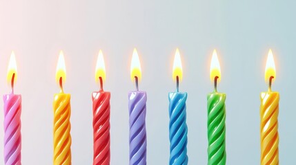 Colorful birthday candles with vibrant flames arranged in a row against a soft background