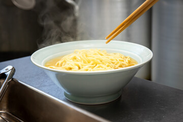 茹でたラーメンの麺をどんぶりに入れる

Put the boiled ramen noodles into a bowl