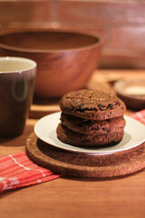 Handmade cookies with chocolate chips on a white plate and fresh milk in a glass. Selective focus
