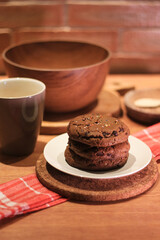 Handmade cookies with chocolate chips on a white plate and fresh milk in a glass. Selective focus