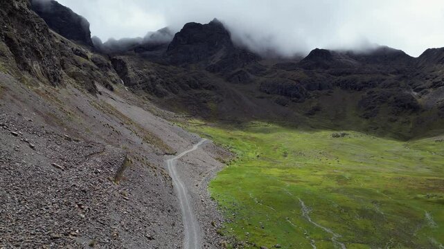 Rugged two track dirt road winds up alpine plateau toward mtn cirque