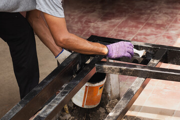 Hand painting anti rust paint on steel at home decorated.