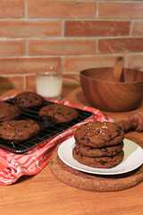 Handmade cookies with chocolate chips on a white plate and fresh milk in a glass. Selective focus