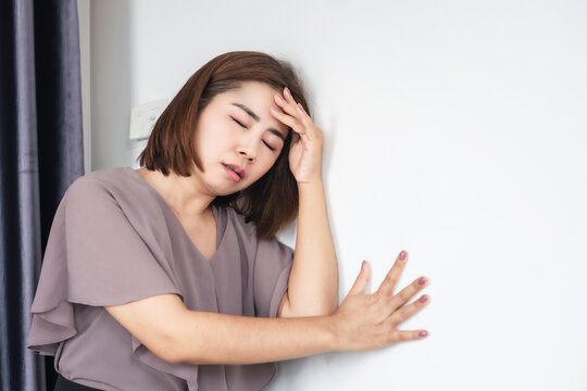 asian woman feeling weak and dizzy due to anemia, experiencing sudden vertigo, headache, and loss of balance, possibly caused by low iron levels or an ischemic stroke , heat stroke