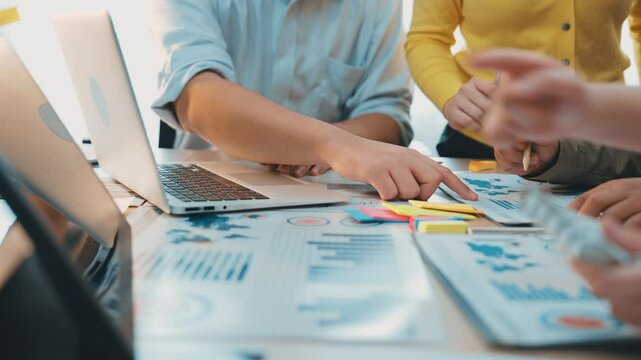 A vibrant office scene showcases a diverse team working together on a project. They analyze data and engage in discussion while using modern technology to visualize results. SACTR - Powered by Adobe