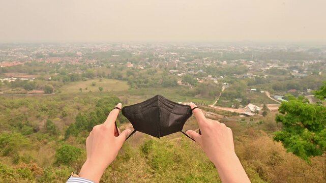 Footage of someone holding a mask for prevent bad air pollution. Air quality masks equivalent to N95, KN95, and FFP2 help provide protection from both PM2. 5 and COVID-19 aerosols.