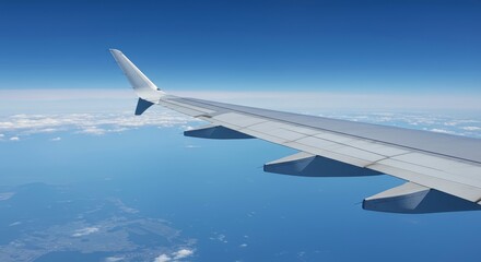 Obraz premium Airplane wing soaring above clouds against clear blue sky 