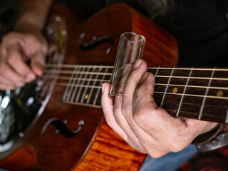 Fototapeta premium Male musician hand play Vintage Resonator acoustic dobro blues slide guitar.