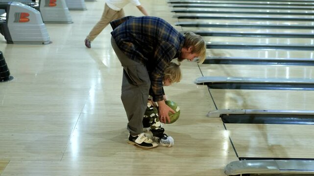 father and little son playing bowling