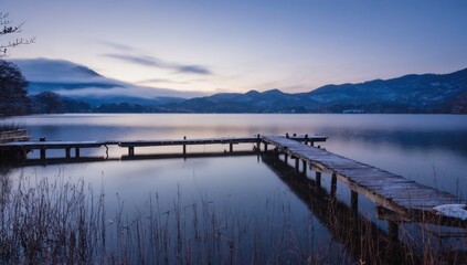 Obraz premium Frozen lake at dawn with wooden pier