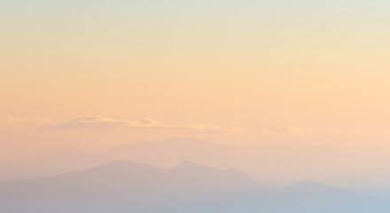 Obraz premium Soft pastel gradient sky with distant mountain silhouette