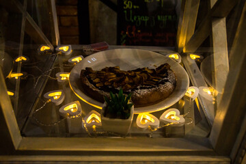 Charming dessert display with heart lights at a cozy cafe