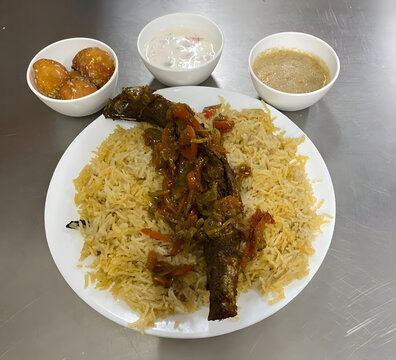 Mandhi biriyani with fish gravy and sweet  Onion Raitha chutney 