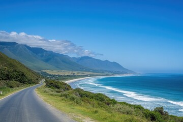 A winding road goes down a hill next to the ocean, with scenic views and potential uses in travel or tourism-related projects