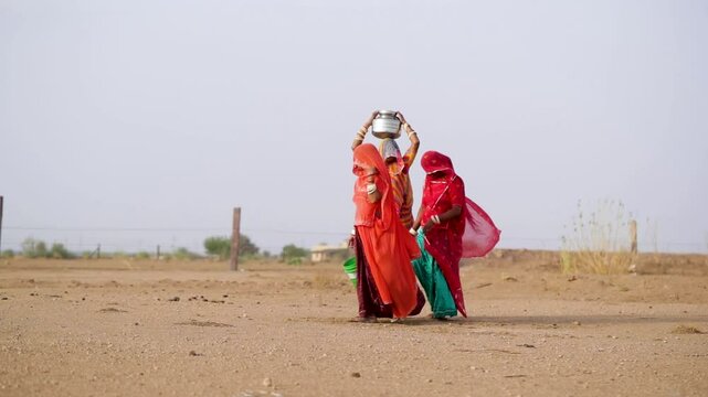 Women collecting in water in a desert in Rajasthan, India