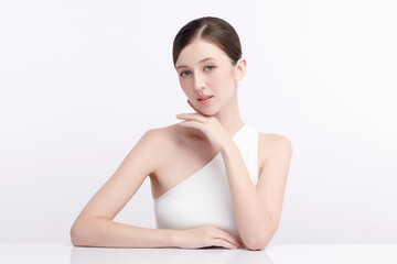 Obraz premium A beautiful young woman with clean, fresh skin against a white background. Skincare, facial treatment, cosmetology, beauty, and spa. An elegant portrait of an woman.