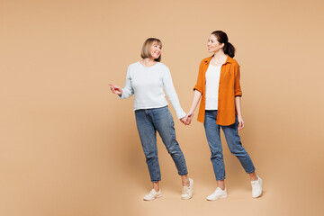 Full body sideways fun elder parent mom 50s years old with young adult daughter two women together...
