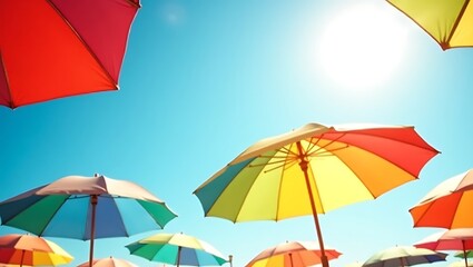 Obraz premium Vibrant rainbow umbrellas sunny day bright blue