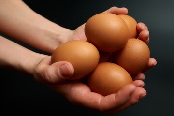 hand holding a brown egg