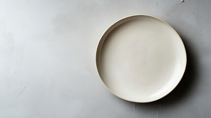 Empty, cream-colored plate on a textured gray surface