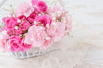 ピンクのカーネーションとバラの白い花かご