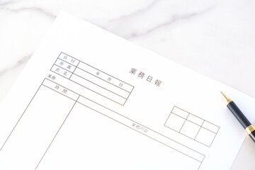 毎日の業務を終えた後、所要時間や作業内容、進捗状況を報告する書類、「業務日報」を記入する
