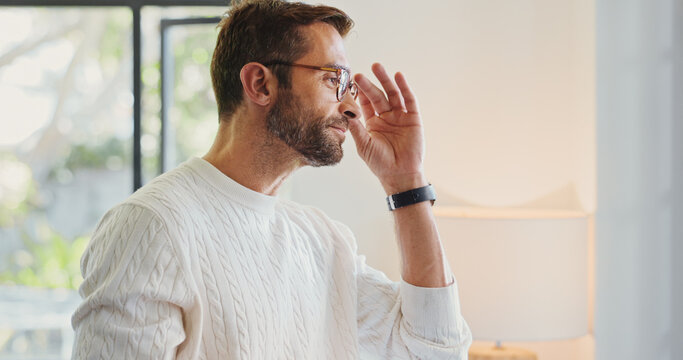 Home, thinking and man in lounge, glasses and smile with optometry, clear vision or thoughtful. Person, apartment or guy in living room, gratitude for eyewear or pride with confidence, space or sight - Powered by Adobe