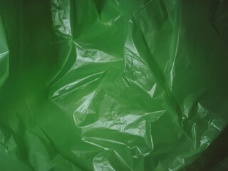 Green crumpled plastic bag texture in dark for environment background