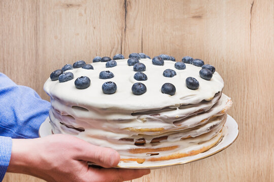 Man holding homemade cake with whipped cream