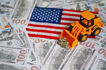A tractor with ore on the background of the US flag And dollar bills. Mining of rare earth metals.