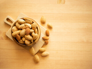 Raw organic whole almonds in a wooden bowl