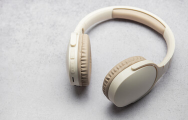 Modern wireless headphones lying on gray marble table