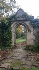 Fototapeta premium Crumbling Archway of a Derelict Manor Surrounded by Nature