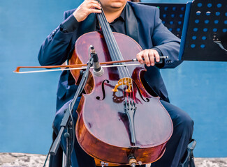 musician in blue suit playing the cello