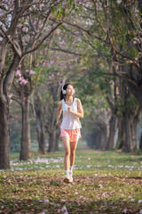 Naklejka premium Asian teenage girl jogging in a park in the morning.
