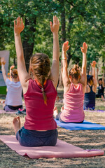 yoga in a park a group of people sitting on yogamates holding th
