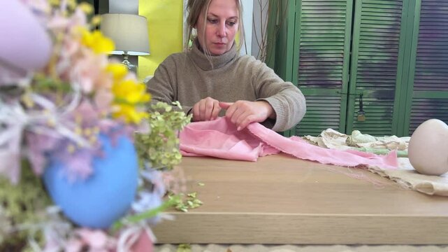 woman tears off a piece of fabric to make pants for a rabbit, master class on making an Easter bunny