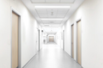 blurred of background. interior of a modern hospital with an empty long corridor. waiting room for patients and families between the corridor with bright white lights. treatment rooms and patient room