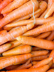 Pile of fresh carrots displayed at groceries store as food background