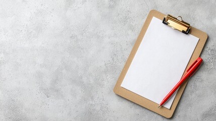 Empty clipboard with a blank sheet and red pen on a gray surface, ready for notes or writing.