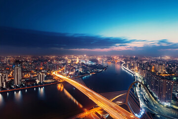 Fototapeta premium Cityscape from the height of an airplane flight at night. Illuminated streets, buildings, bridges, embankment