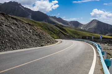 Asphalt road with mountain nature landscape on a sunny day