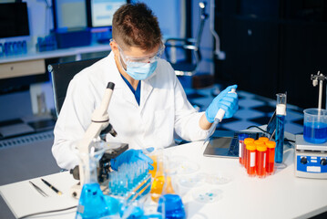 scientists in lab coats conducting research, handling glassware, and working with chemicals