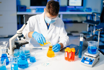 male scientist working with micro pipettes analyzing biochemical samples, advanced science chemical...