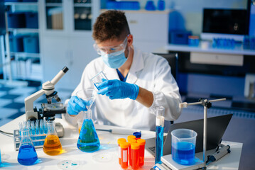 scientists in lab coats conducting research, handling glassware, and working with chemicals