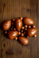 A pile of chocolate eggs and candies, top view. Chocolate background