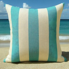 A striped teal and white pillow placed on a sandy beach