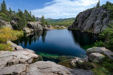 A crystal-clear lake surrounded by massive boulders, reflecting the deep blue sky