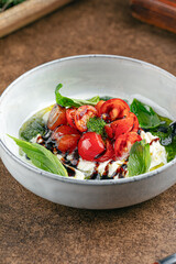 Portion of gourmet appetizer with tomato and soft cheese