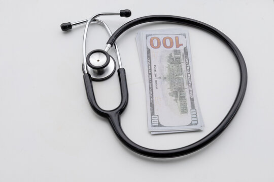 A stethoscope placed near a stack of money, illustrating healthcare billing and financial concerns.